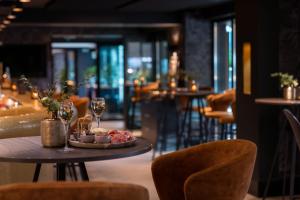 uma mesa com um prato de comida e copos de vinho em Hotel Lugano em Knokke-Heist
