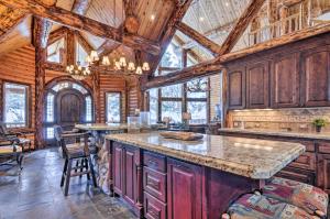 a kitchen with wooden ceilings and a large center island at Delightful Cabin Vacation Rental with Fire Pit! in Duck Creek Village
