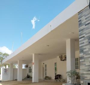 a large white building with a white roof at Cabañas Berakah in Coveñitas