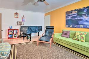 a living room with a green couch and a piano at Santa Monica Townhome - Close to Beach! in Los Angeles