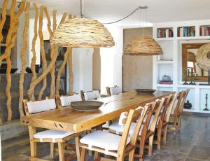 a dining room with a wooden table and chairs at Kasbah Darshan in Cala Vadella