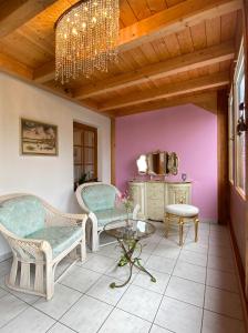 a room with two chairs and a table and a chandelier at Haus bei der Linden Ferienwohnungen in Schwangau