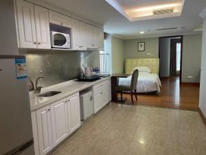 eine Küche mit einem Waschbecken und ein Bett in einem Zimmer in der Unterkunft Yo Le Le Apartment in Guangzhou