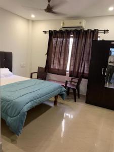 a bedroom with a bed and a window with a fan at Vishram Homestay, Malpe Beach, Udupi in Malpe +11 photos