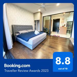 a bedroom with a bed with a blue comforter at Almas Suites Puteri Harbour in Nusajaya