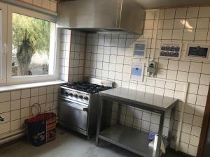 a kitchen with a stove and a window at Centre Louis Delobbe in Olloy-sur-Viroin