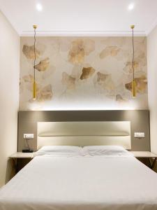 a bedroom with a white bed and a wall with flowers at Flower Garden Hotel in Rome