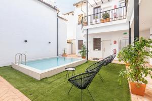 cortile con piscina e 2 sedie di BHost - Regina IV a Cordoba