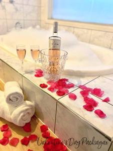 a bathroom with two glasses of champagne and red roses at The Romantic Pink English Cottage at Tamborine Mountain in Mount Tamborine