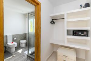 a bathroom with a toilet and a glass door at Imani - Beachfront Penthouse with Spectacular Ocean Views in Kiwengwa