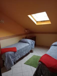 een slaapkamer met 2 bedden en een dakraam bij Le mansarde di Via Isonzo in Chieti