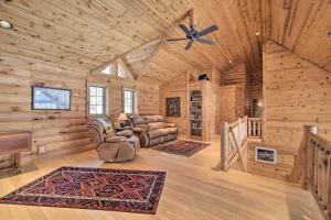 a living room in a log cabin with a ceiling fan at Spacious House with Boat Dock on Red Cedar Lake in Mikana