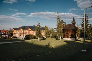 ein großes Gebäude mit einer Kirche im Hof in der Unterkunft Vila Kollár Vysoké Tatry in Vysoké Tatry