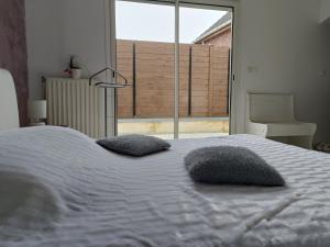 a bedroom with a large bed with two pillows on it at Virtuel Spa in Achicourt