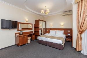 Habitación de hotel con cama y TV en Wind Rose Hotel & SPA en Sochi