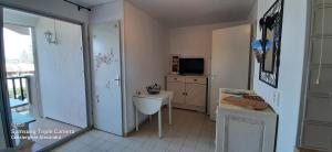 W łazience znajduje się umywalka, biurko i telewizor. w obiekcie Les Capitelles : Appartement vue montagne en residence avec piscine -sur le front de mer w mieście Saint-Cyprien