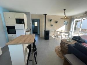 kuchnia i salon ze stołem i kanapą w obiekcie Maison au calme près des plages w mieście Le Poiroux +16 zdjęć