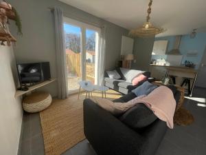 salon z kanapą i stołem w obiekcie Maison au calme près des plages w mieście Le Poiroux