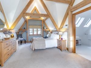 a bedroom with a white bed and wooden beams at Chestnut Cottage in Leighton