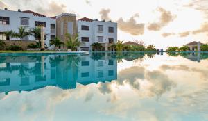 a swimming pool in front of a building with a reflection in the water at Sultan Palace Beach Retreat Mombasa in Mombasa