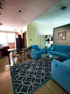 a living room with a blue couch and a table at Serenity Paradise 2BR in Marina in Dubai