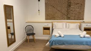 1 dormitorio con 1 cama con manta azul y silla en Sevilla deluxe suites, en Sevilla