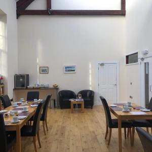 a dining room with wooden tables and chairs at Grammar Lodge Guest House in Campbeltown