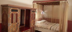 1 dormitorio con cama ornamentada y dosel en Riad Ifoulki, en Marrakech