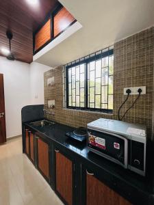 uma cozinha com um balcão com um micro-ondas em St. Francis Xavier em Old Goa