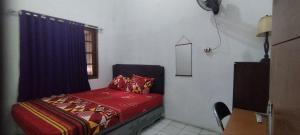 a small bedroom with a bed and a window at FAI Bogor Backpacker by SPAZIE in Bogor