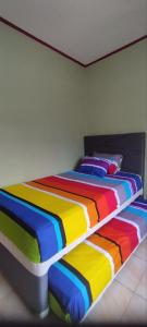 un letto di colore arcobaleno in una camera di FAI Bogor Backpacker by SPAZIE a Bogor
