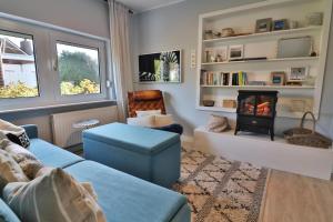 a living room with a couch and a fire place at Langeooger Viermaster - Blaues Segel in Langeoog
