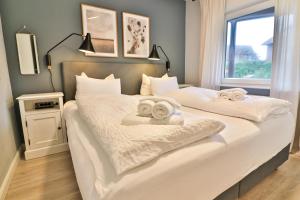 a bedroom with two beds with towels on them at Langeooger Viermaster - Blaues Segel in Langeoog