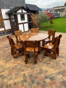 un tavolo in legno e sedie su un patio in mattoni di Ferienwohnung sentio-comfortable Saalfeld a Saalfeld