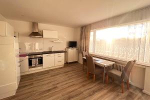 a kitchen with a table and chairs and a window at Cozy apartment with balcony in Leverkusen