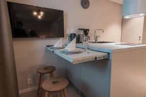 a kitchen with a counter with stools and a sink at Forenom Aparthotel Tampere Kauppakatu in Tampere