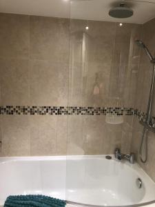 a bathroom with a bath tub with a shower at The Cottage Cox Hill Chacewater in Truro