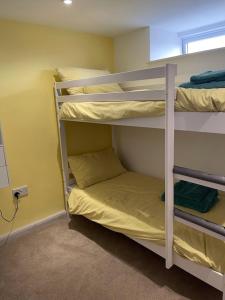 a room with three bunk beds in a room at The Cottage Cox Hill Chacewater in Truro