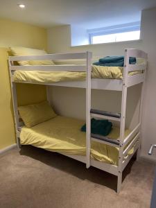 two bunk beds in a room with a window at The Cottage Cox Hill Chacewater in Truro