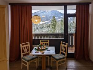 a dining room with a table and chairs and a large window at Apartment Keppler in Bad Goisern