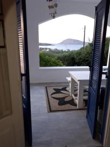 a room with a table and a view of the ocean at LEROS VILLA BLEFOUTI in Alinda