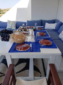 einen Tisch mit Teller Essen drauf mit einer Couch in der Unterkunft LEROS VILLA BLEFOUTI in Alinda