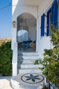 ein weißes Haus mit blauen Türen und Treppen in der Unterkunft LEROS VILLA BLEFOUTI in Alinda