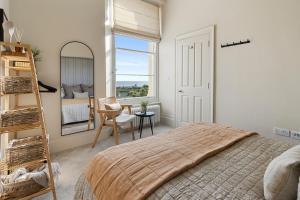 a bedroom with a bed and a ladder and a window at Seabreeze in Teignmouth