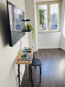 una mesa con TV y una silla en una habitación en Au petit cocon de coco, en Guebwiller