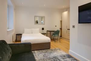 Un dormitorio con una cama, un sofá y un televisor. en Charles Hope Swindon, en Swindon