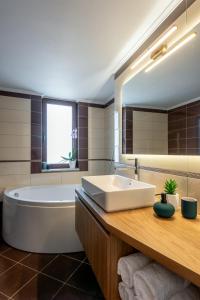 La salle de bains est pourvue d'une baignoire blanche, d'un lavabo et d'une baignoire. dans l'établissement Soleado apartment, à La Canée