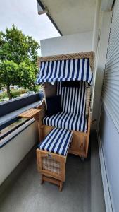 庫克斯港的住宿－NordseeGlück，阳台的门廊配有椅子和遮阳伞