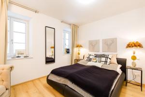 a bedroom with a large bed and a chair at Mozart's Garden Villa in Salzburg