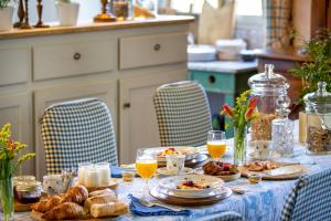 una mesa con comida para el desayuno y bebidas en ella en Château du Tertre, en Arsac